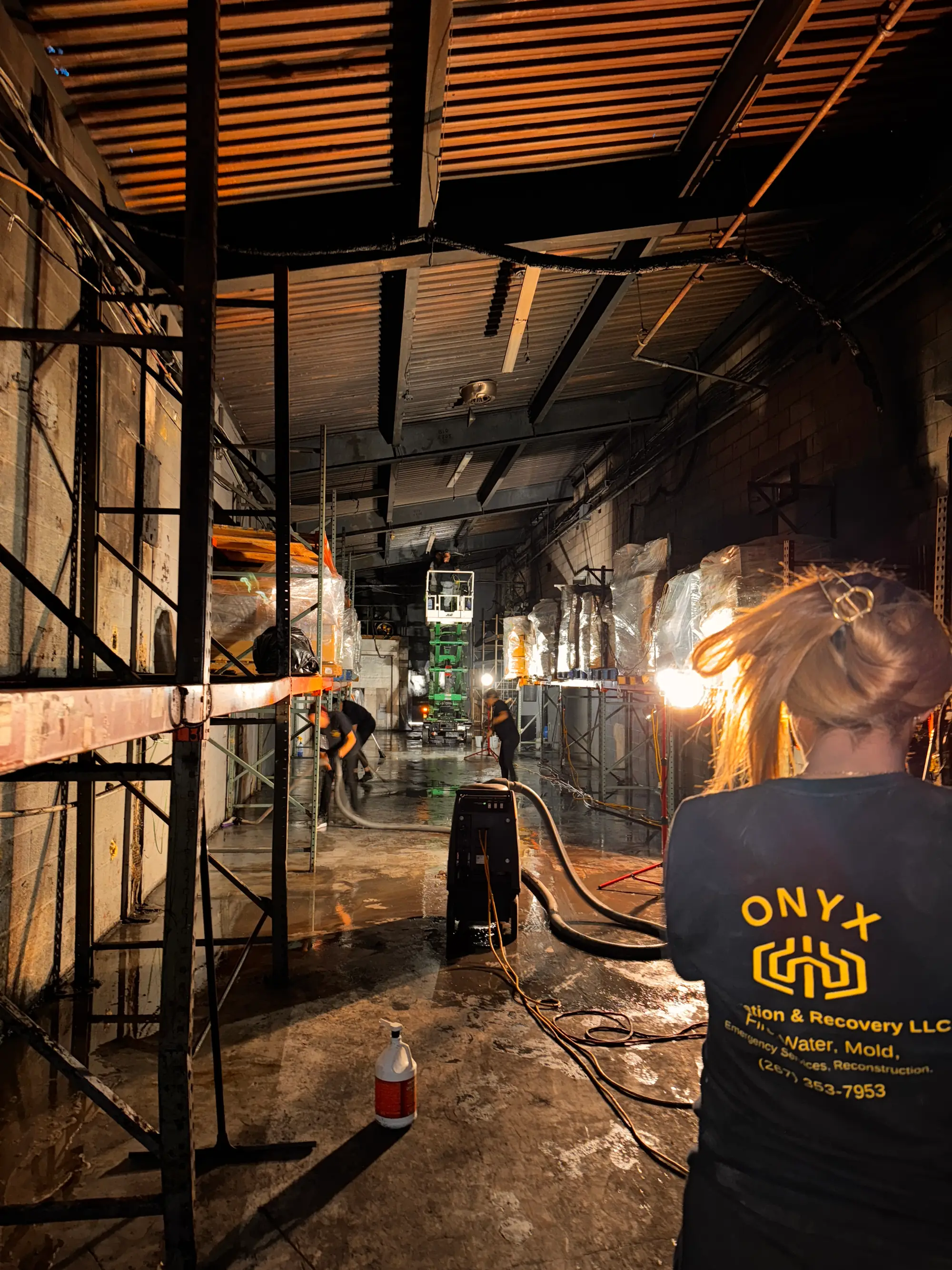 Onyx crew member setting up restoration equipment in a commercial warehouse