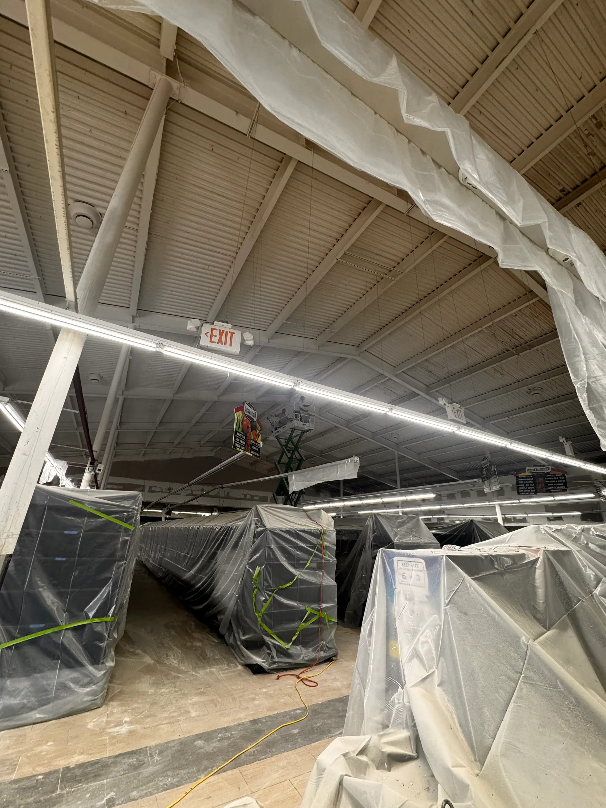 Plastic containment sheeting over store shelving during commercial water damage cleanup