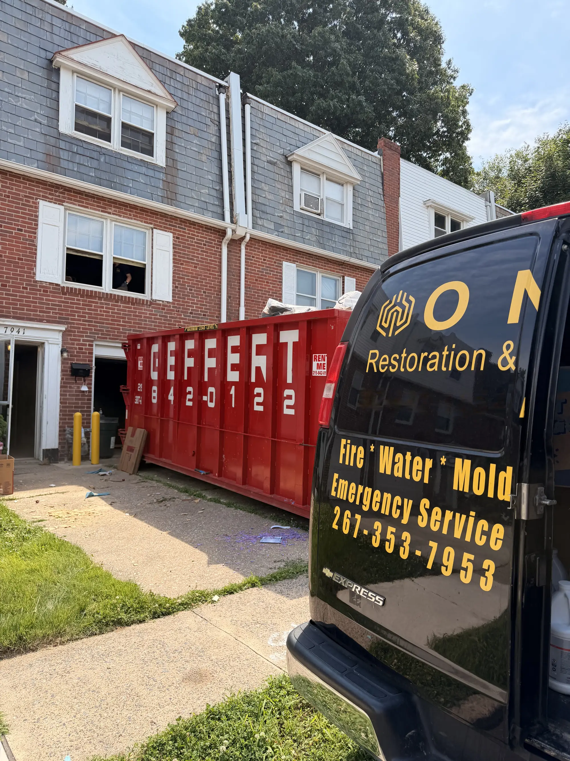 Onyx Restoration & Recovery van beside a dumpster at a restoration job site