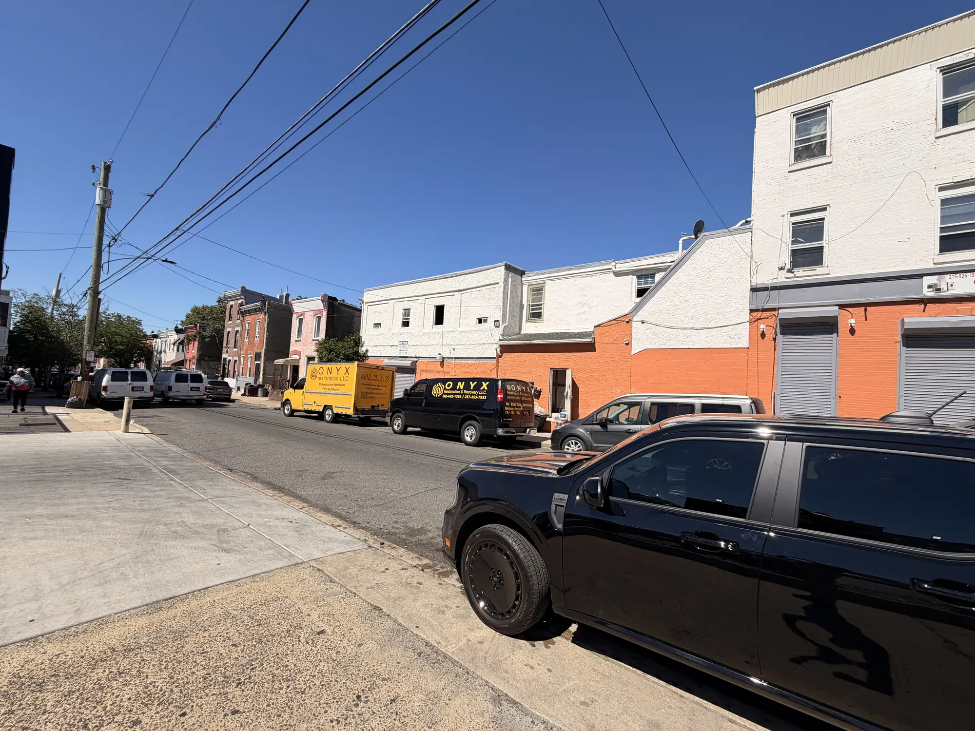 Onyx trucks parked on a Philadelphia street outside a job site