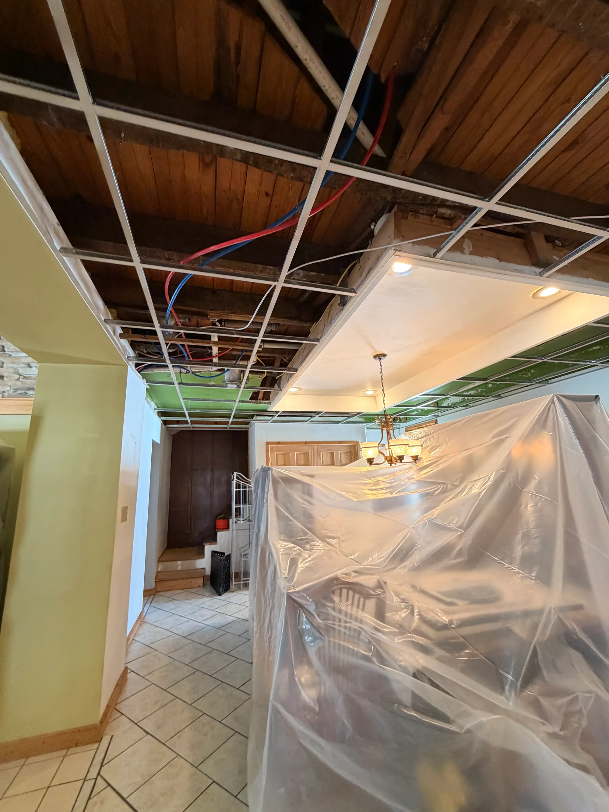 Plastic containment under an opened ceiling during residential mold remediation