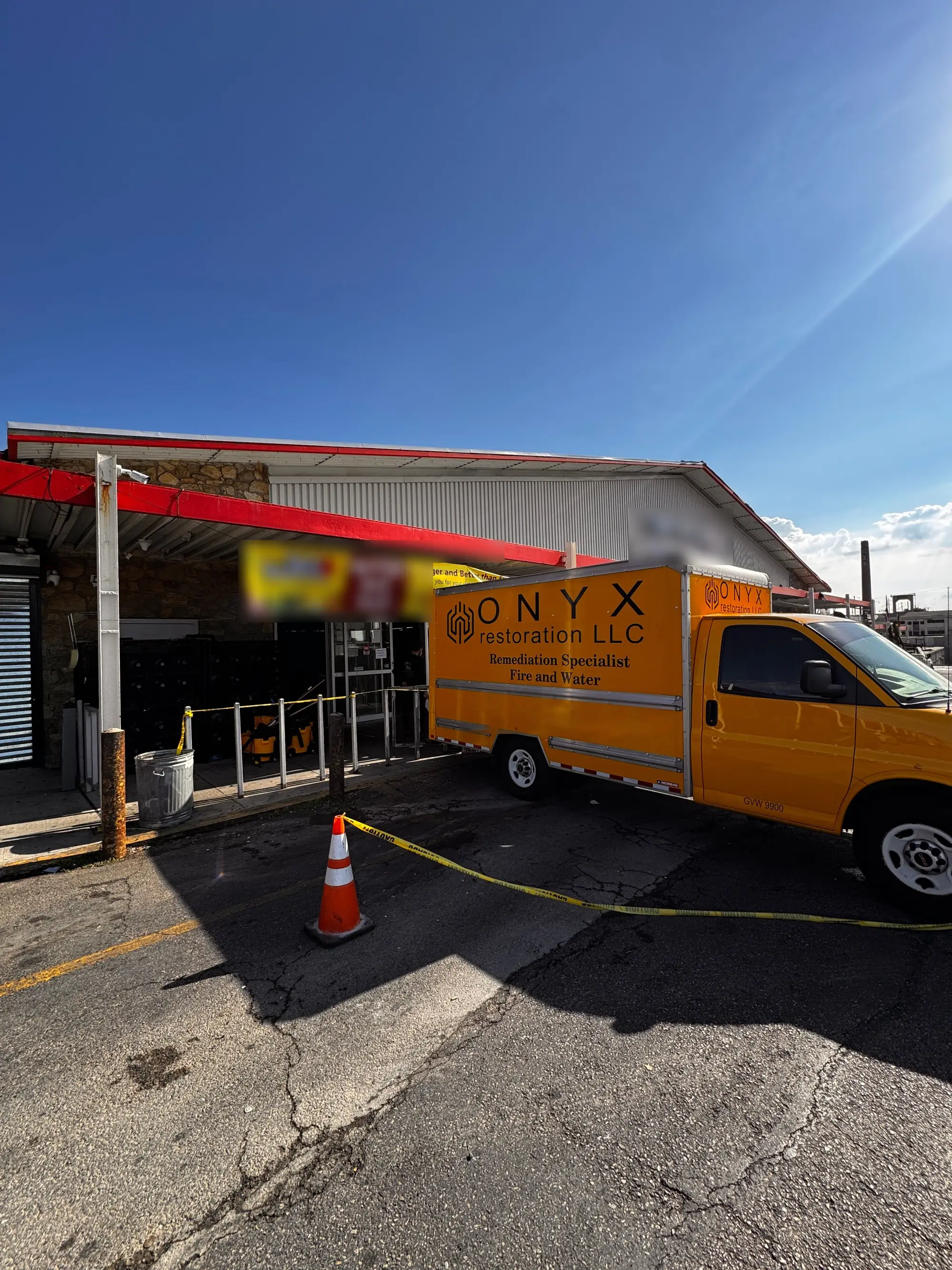 Onyx box truck parked at a taped-off storefront during commercial restoration